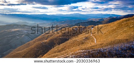 Kopaonik mountain range in Serbia. Aerial view on Kopainik National Park. Sunset under mountains, hills and meadows. Winding road along the mountains