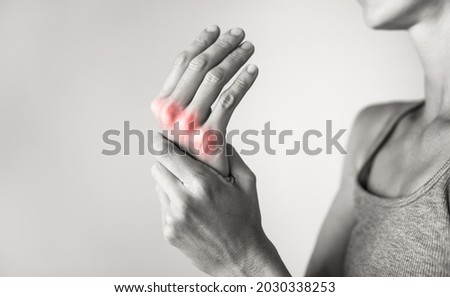 Woman suffering from pain in hands and fingers, arthritis inflammation. Red highlight Royalty-Free Stock Photo #2030338253