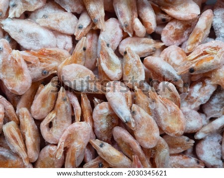 Frozen shrimp with ice on the supermarket counter. A shop window with seafood. Photo of food. Salad ingredients.