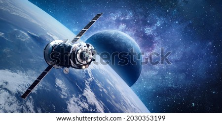 Russian spaceship on orbit of planet Earth. View from ISS station. Blue planets in deep space. Sci-fi wallpaper. Elements of this image furnished by NASA Royalty-Free Stock Photo #2030353199