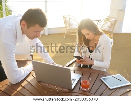 business couple sitting  together at the summer coffee. street cafe. outdoor shot. Serious business  man and woman. White collar. 