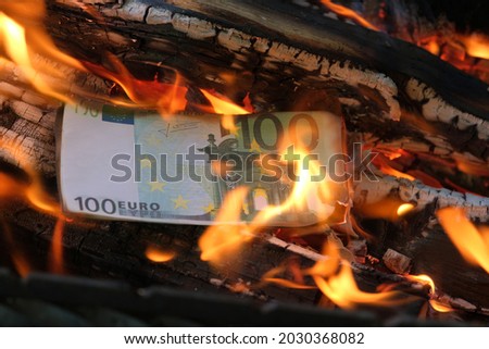 a 100 euro banknote is burning in a flame of fire. Close-up, horizontal photo. Concept - crisis, default, economic decline. Royalty-Free Stock Photo #2030368082