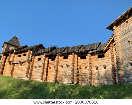 Wooden fortress wall against the sky. Medieval fortress with high walls. Wooden installation in the style of an ancient city. Park "Kievan Rus" Kiev region, village Kopachevo, May 10, 2021.