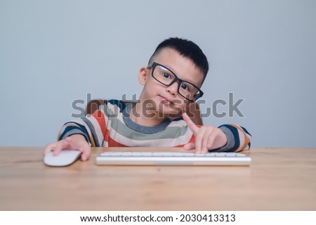 smart kids, Cute Asian Boy using a mouse and computer keyboard, homeschooling, online study, home quarantine, online learning, corona virus or education technology concept, 5 years old.