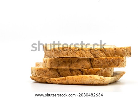 Isolated stack of whole wheat bread on white background. Close-up image, side view of brown whole wheat bread, low angle view.