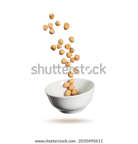 Chickpeas is flying in the air. Chickpeas and white plate isolated on white background. Creative concept cooking food. Royalty-Free Stock Photo #2030490611