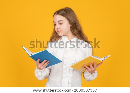 serious kid in white shirt ready to study do homework reading book on yellow background, literature