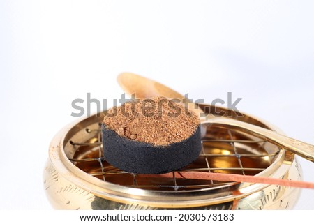 A closeup of burning incense powder on a white background