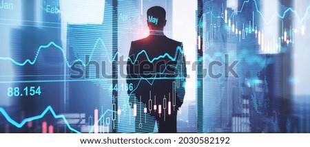Young man in office with panoramic blurry city view and forex graph. Finance, trade, communication, executive and success concept