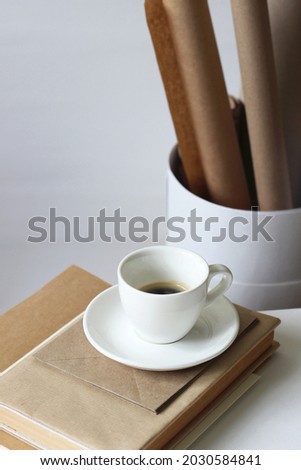 Minimal Design Studio Interior. Cup of Coffee  with Papers on White Office Desk.