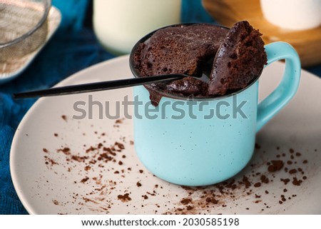 mugcake is microwaved. Homemade cupcake in a mug is on a plate. Chocolate brownie mug cake. Easy cooking concept, microwave baking. muffin chocolate. High quality photo Royalty-Free Stock Photo #2030585198
