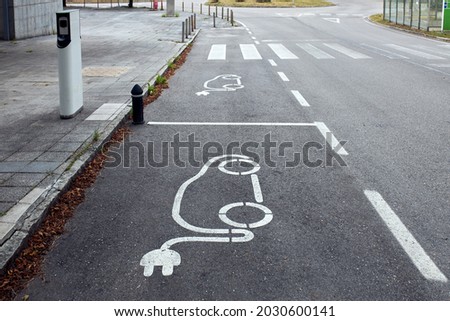 A high-angle shot of an electric vehicle symbol on the street