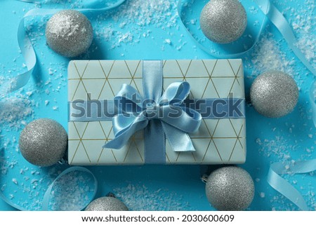 Gift box and Christmas accessories on blue background