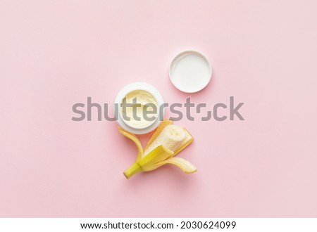 Jar of natural cream and fresh banana on color background