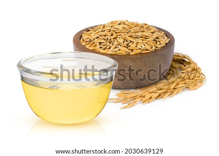 Rice bran oil extract in glass bowl with paddy unmilled rice in wooden bowl isolated on white background.  Royalty-Free Stock Photo #2030639129