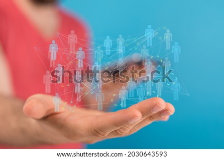 A 3D rendering of people silhouettes in the network team with a real person holding it - digital network concept