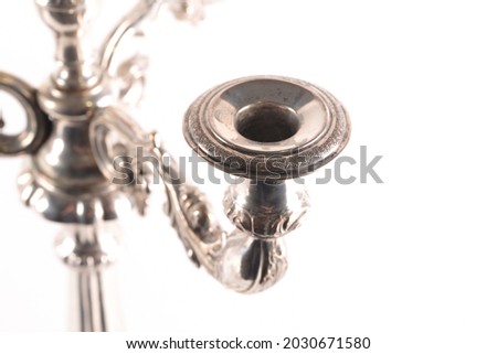 An antique silver candelabra, photographed on a white background