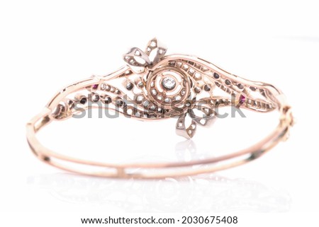 An antique diamond bangle filled with old cut diamonds. Isolated on white with a subtle reflection