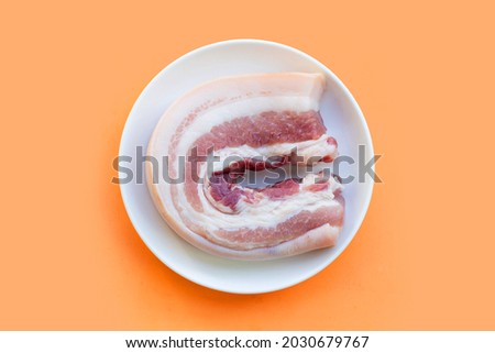 Streaky pork in white plate on orange background. Royalty-Free Stock Photo #2030679767