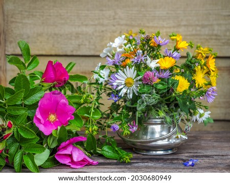 Summer bouquets of wildflowers and a bouquet of dark pink chickweed on the table of a country house on a sunny day