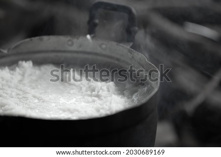 Blurred picture of white smoke from cooked rice by boiling in pot on stove of countryside kitchen. Vintage tone