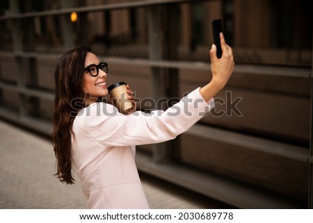 Young businesswoman using the phone. Female manager taking selfie photo.