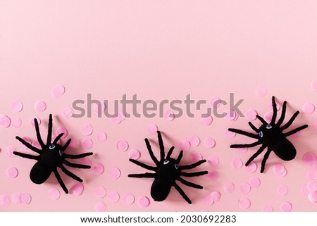 Halloween card with black spiders and confetti on pink background, flat lay, copy space, top view