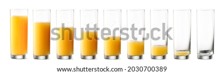 Glasses with different amount of orange juice on white background Royalty-Free Stock Photo #2030700389