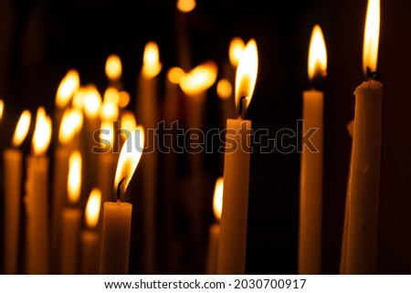Many long burning candles background. Candles flames with black background. Concepts of christmas, religion, party.