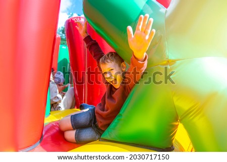 Child play on colorful playground trampoline. Kids jump in inflatable bounce castle on birthday party.  Horizontal childhood poster, greeting cards, headers, website. Royalty-Free Stock Photo #2030717150