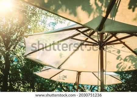  Garden Retreat: Basking in Sunlight Under a White Umbrella Royalty-Free Stock Photo #2030751236