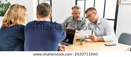 Group of middle age business workers working at the office.