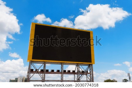 A large LED screen with blue sky background