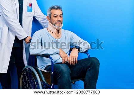 Handsome middle age man with grey hair on wheelchair wearing cervical collar depressed and worry for distress, crying angry and afraid. sad expression.  Royalty-Free Stock Photo #2030777000