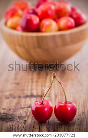 Organic Rainier Cherries in a bowl on old wooden background