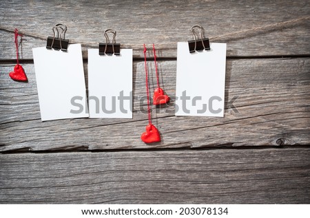 three photo paper attach to rope with clothes pins on wooden background
