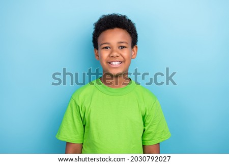 Photo of little brunet boy wear green t-shirt isolated on blue color background Royalty-Free Stock Photo #2030792027