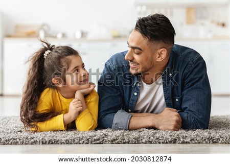 Happy Middle Eastern Family Dad And Daughter Relaxing Together On Floor, Portrait Of Happy Young Arab Father Bonding With His Cute Female Child At Home, Looking At Each Other And Smiling, Closeup