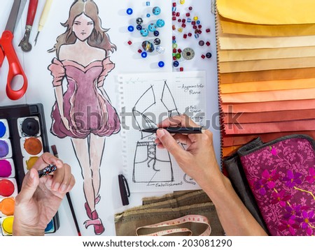 Top view of fashion designer drawing illustration with material sample