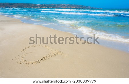 Shape of heart on the beach, sea and mountains background