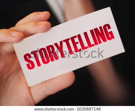 Businessman holding a card with word Storytelling. Copywriting telling stories marketing concept
