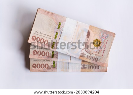 Much Banknote of One Thousand Thai Baht on coins. Thai currency, medium of exchange, and stock market concept . Royalty-Free Stock Photo #2030894204