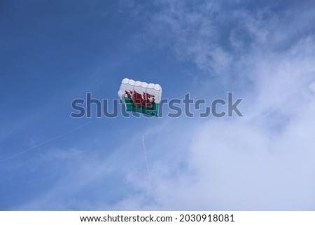 Welsh Dragon.  Box kite featuring a red dragon flying up high in a blue sky.