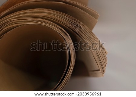Kraft paper rolled into a roll, paper for printing vintage postcards, napkins, menus, cards. Printing materials at the printing company. Selective focus. Top view