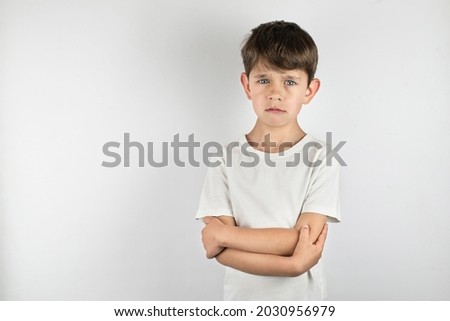 The little boy hugs himself, he has a sad face, someone has offended him, scared him, the boy is about to cry. The concept of preserving the rights of the child, protecting children from violence Royalty-Free Stock Photo #2030956979