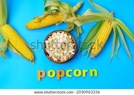 National Popcorn Day. Popcorn with corn cobs on a blue background