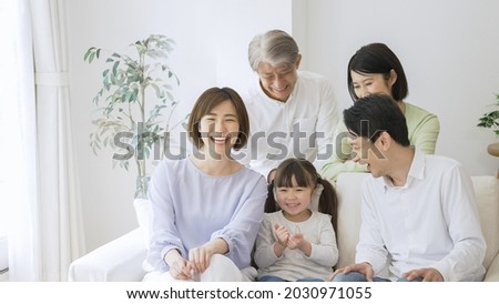 Asian family relaxing at home Royalty-Free Stock Photo #2030971055