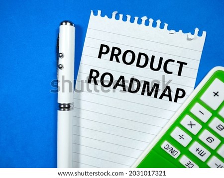 Education concept.Text PRODUCT ROADMAP writing on notepaper with pen and calculator on blue background.