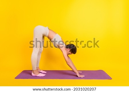 Profile side view portrait of attractive sportive girl doing physical work out endurance isolated over bright yellow color background