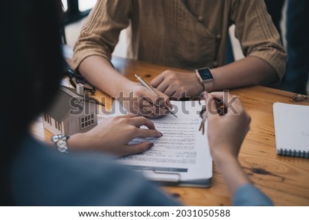 Close up of Business woman pointing and signing agreement for buying house. Bank manager and real estate concept.